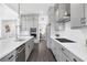 A bright kitchen features gray cabinets, white countertops, stainless appliances, and wood tile floors at 14513 Winter Stay Dr, Winter Garden, FL 34787
