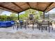 Cozy outdoor lounge featuring a stone fireplace, comfortable seating, and shaded pergola, great for entertaining at 14513 Winter Stay Dr, Winter Garden, FL 34787
