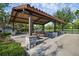 Open-air picnic shelter featuring stone columns, grill, tables, and a metal fence for outdoor gatherings at 14513 Winter Stay Dr, Winter Garden, FL 34787
