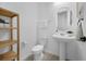 This powder room features a pedestal sink, modern toilet and open shelving for storage at 14513 Winter Stay Dr, Winter Garden, FL 34787