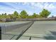 Well-maintained tennis court with net, surrounded by lush greenery and fencing for privacy at 14513 Winter Stay Dr, Winter Garden, FL 34787