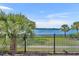 Scenic view from the patio featuring a black metal fence, palm trees, and sparkling lake at 1460 Lake Shadow Cir # 7102, Maitland, FL 32751