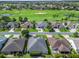 Overhead view of homes in a golf course community, showcasing well-maintained lawns and beautiful landscaping at 1642 Pennecamp Dr, The Villages, FL 32162