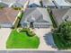 Aerial view of a well-kept home showcasing landscaping and a three-car garage at 1642 Pennecamp Dr, The Villages, FL 32162