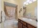Bathroom with a shower-tub combo and cherry wood vanity with sink at 1642 Pennecamp Dr, The Villages, FL 32162
