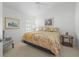 Bright bedroom with neutral carpeting, complemented by a decorative floral-patterned bedspread at 1642 Pennecamp Dr, The Villages, FL 32162
