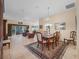 Open-concept living space with dining area, tile floors, and a sliding glass door at 1642 Pennecamp Dr, The Villages, FL 32162