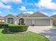 Well-maintained single-story home featuring a lush lawn and an attached three-car garage at 1642 Pennecamp Dr, The Villages, FL 32162