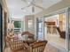 Bright Florida room with wicker furniture, ceiling fan, and views through the sliding glass doors to the kitchen at 1642 Pennecamp Dr, The Villages, FL 32162