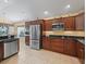 Well-lit kitchen with stainless steel appliances and custom cabinetry at 1642 Pennecamp Dr, The Villages, FL 32162