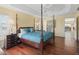 Elegant main bedroom with hardwood floors, ceiling fan, and a four-post bed offering comfort and style at 1642 Pennecamp Dr, The Villages, FL 32162