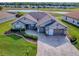 Beautiful home featuring a manicured lawn, paver driveway, and stunning water views at 17563 Se 122Nd Ter, Summerfield, FL 34491