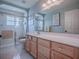 Bright bathroom with a shower over bath, framed shower screen and traditional vanity unit at 17563 Se 122Nd Ter, Summerfield, FL 34491