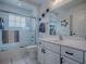 Clean bathroom featuring a shower over bath with framed shower screen and modern vanity unit at 17563 Se 122Nd Ter, Summerfield, FL 34491