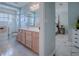 Bright bathroom with a shower over bath, framed shower screen and traditional vanity unit at 17563 Se 122Nd Ter, Summerfield, FL 34491