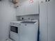 Functional laundry room with a modern washer and dryer, ample storage cabinets for organization at 17563 Se 122Nd Ter, Summerfield, FL 34491