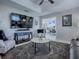 Open-concept living room with a wall-mounted television and a marble-topped coffee table at 17563 Se 122Nd Ter, Summerfield, FL 34491
