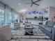 Bright living room with a ceiling fan, view of the modern kitchen, and a cozy seating area at 17563 Se 122Nd Ter, Summerfield, FL 34491
