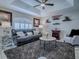 Comfortable living room with tray ceilings, black leather sofa, and light gray walls at 17563 Se 122Nd Ter, Summerfield, FL 34491