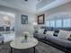 Cozy living room features a black leather sofa with throw pillows and a faux marble-topped coffee table at 17563 Se 122Nd Ter, Summerfield, FL 34491