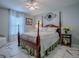 Charming bedroom with a four-poster bed, decorative wall art, and plenty of natural light from the window at 17563 Se 122Nd Ter, Summerfield, FL 34491