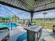 Relaxing covered patio featuring stylish furniture, fire table, and screened pool area at 17563 Se 122Nd Ter, Summerfield, FL 34491