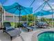 Screened in pool with sun umbrellas and seating offers a relaxing outdoor experience at 17563 Se 122Nd Ter, Summerfield, FL 34491