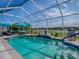 Sparkling pool area features screened enclosure, seating areas, and serene backyard views at 17563 Se 122Nd Ter, Summerfield, FL 34491