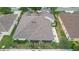 An aerial perspective of the home showing the roof, patio, and surrounding landscape at 1828 Hollow Branch Way, The Villages, FL 32162