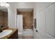 Well-lit bathroom showcasing a vanity with granite countertop and a tiled shower over tub at 1828 Hollow Branch Way, The Villages, FL 32162
