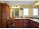 Bathroom featuring granite countertops, wooden cabinets, and a vanity area with chair at 1828 Hollow Branch Way, The Villages, FL 32162