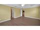 Bedroom showcasing wood floors, tray ceiling, and doorways to the bathroom at 1828 Hollow Branch Way, The Villages, FL 32162