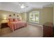 Comfortable bedroom featuring wood-look floors, ceiling fan, and a large window for ample natural light at 1828 Hollow Branch Way, The Villages, FL 32162