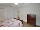 Bedroom featuring wood-look floors, a ceiling fan, and access to an ensuite closet at 1828 Hollow Branch Way, The Villages, FL 32162
