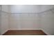 Walk-in closet with metal shelving and wood flooring at 1828 Hollow Branch Way, The Villages, FL 32162