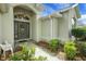 Close up of the front entryway with beautiful landscaping, arched window and leaded glass front door at 1828 Hollow Branch Way, The Villages, FL 32162