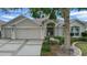 Beautiful home with a well-maintained lawn, mature landscaping, and a welcoming entryway at 1828 Hollow Branch Way, The Villages, FL 32162