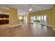 Open living room with wood floors, bar, and sliding glass doors to the lanai at 1828 Hollow Branch Way, The Villages, FL 32162