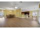Open concept living room features hardwood floors, dining area and breakfast bar to kitchen at 1828 Hollow Branch Way, The Villages, FL 32162
