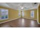 Spacious primary bedroom with tray ceiling, hardwood floors, and plenty of natural light at 1828 Hollow Branch Way, The Villages, FL 32162