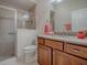 Bathroom featuring glass enclosed shower and wooden vanity with granite countertops at 2044 Larkwood Ct, The Villages, FL 32162