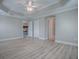 Well-lit bedroom features a decorative tray ceiling, access to the kitchen and ensuite bathroom at 2044 Larkwood Ct, The Villages, FL 32162