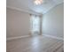 Bedroom featuring light gray walls, light wood-look flooring, and window with lace curtains at 2044 Larkwood Ct, The Villages, FL 32162