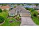Well-maintained home with a two-car garage, a beautifully landscaped yard, and a winding paver driveway at 2044 Larkwood Ct, The Villages, FL 32162