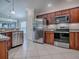 Well-equipped kitchen with stainless steel appliances, dark wood cabinets, and granite countertops at 2044 Larkwood Ct, The Villages, FL 32162
