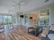 Spacious lanai with wood-look tile flooring, comfortable seating, and a view of the kitchen at 2044 Larkwood Ct, The Villages, FL 32162