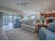 Open-concept living room with comfortable seating, neutral decor, and access to the outdoor patio at 2044 Larkwood Ct, The Villages, FL 32162