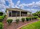 This home features a private patio with landscaping, screened windows, and elegant rod iron-style railing at 2044 Larkwood Ct, The Villages, FL 32162