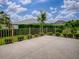 Enjoy the outdoors from this home's concrete patio and metal railing surrounded by manicured landscaping at 2044 Larkwood Ct, The Villages, FL 32162