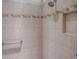Tiled shower featuring decorative accent border and a convenient recessed shelf at 2044 Larkwood Ct, The Villages, FL 32162